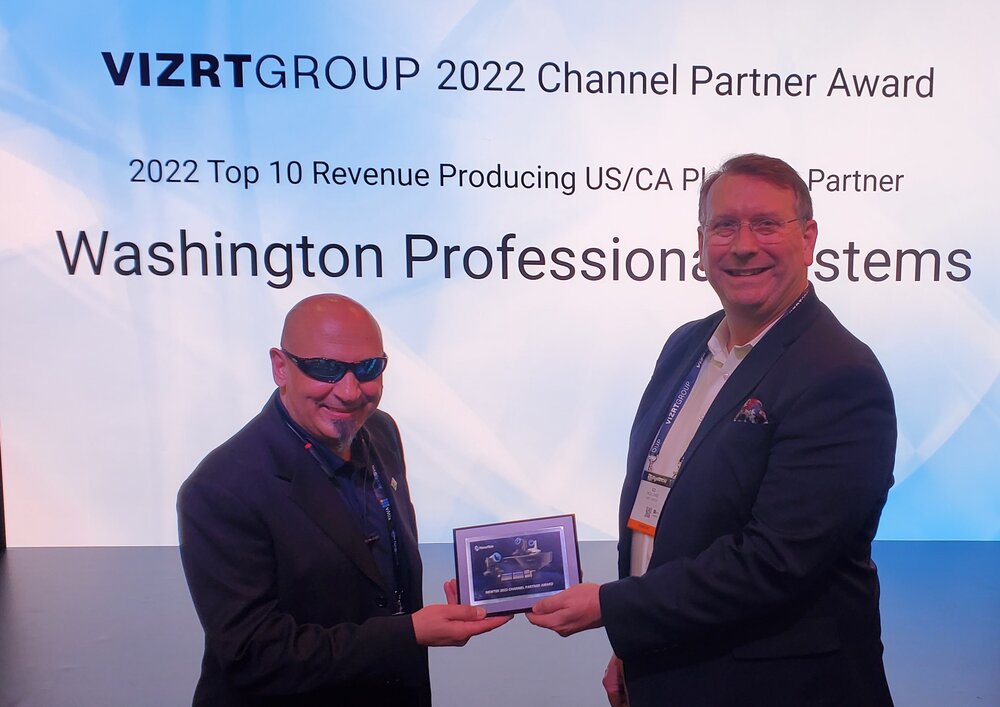 Dominic Cappelletti of WPS receiving the Vizrt Group 2022 Channel Partner Award from Ed Holland of Vizrt Group